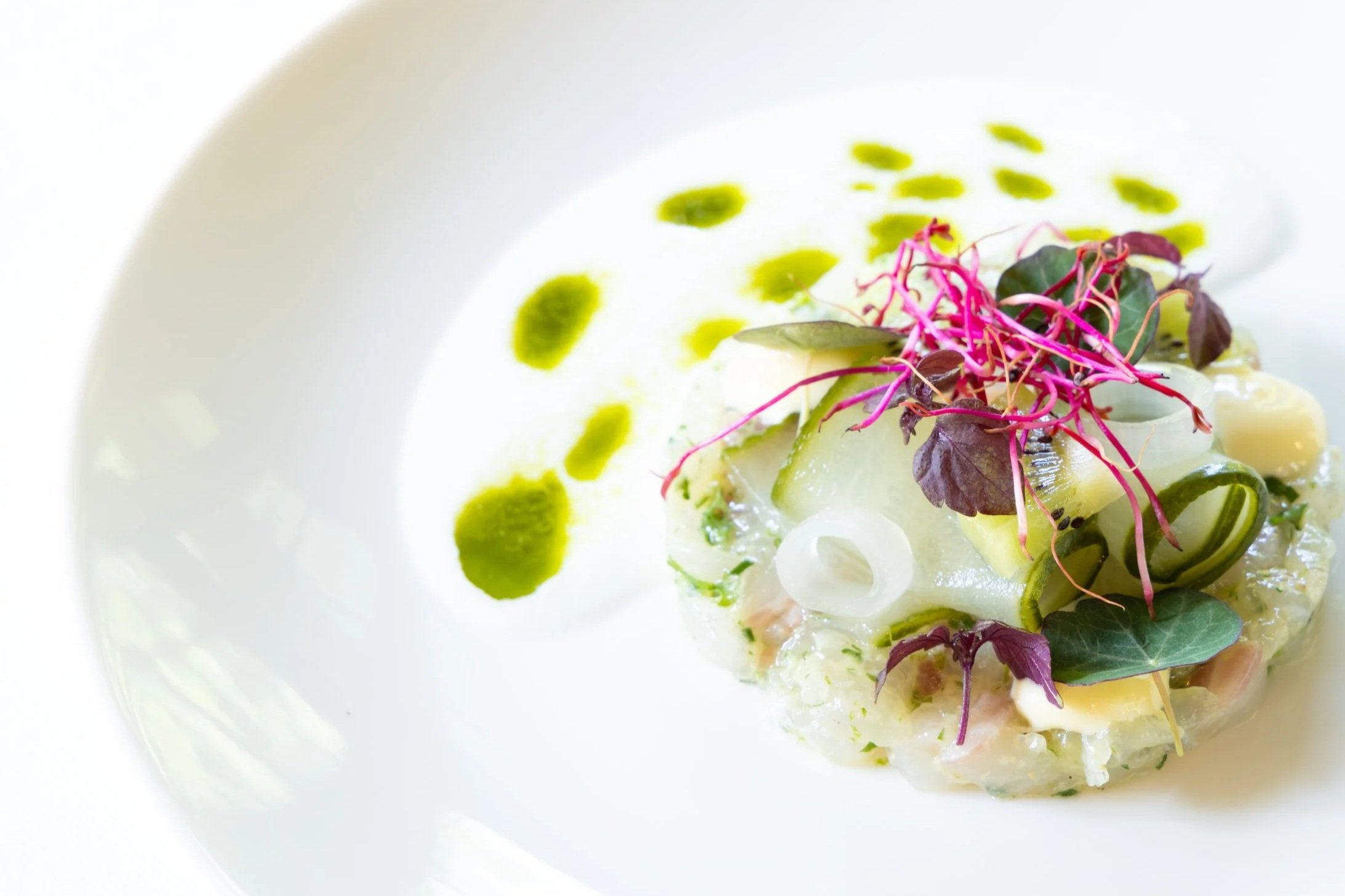 Afbeelding van een gerecht met vis, sjalot en dressing