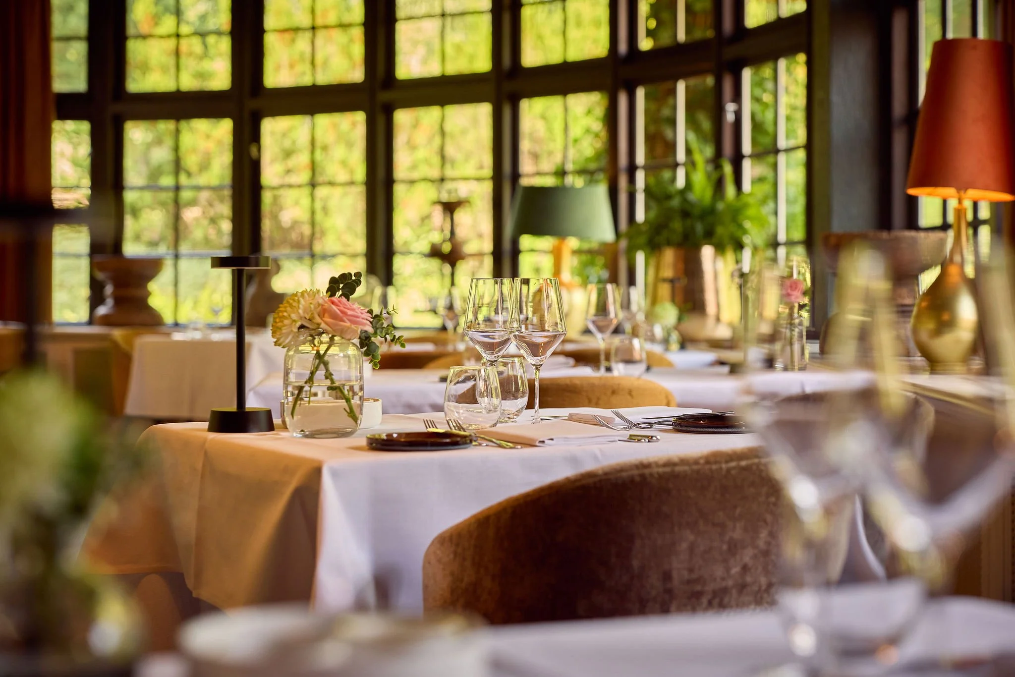 Tafel in restaurant ingedekt met wijnglazen, waterglazen, bestek