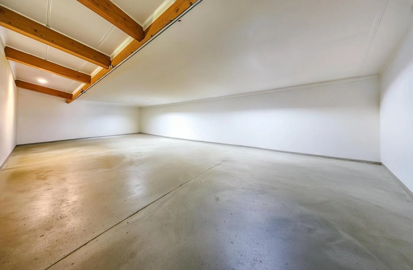 interior space with polished concrete flooring and exposed utilities, representing commercial concrete floor installation and finishing services.