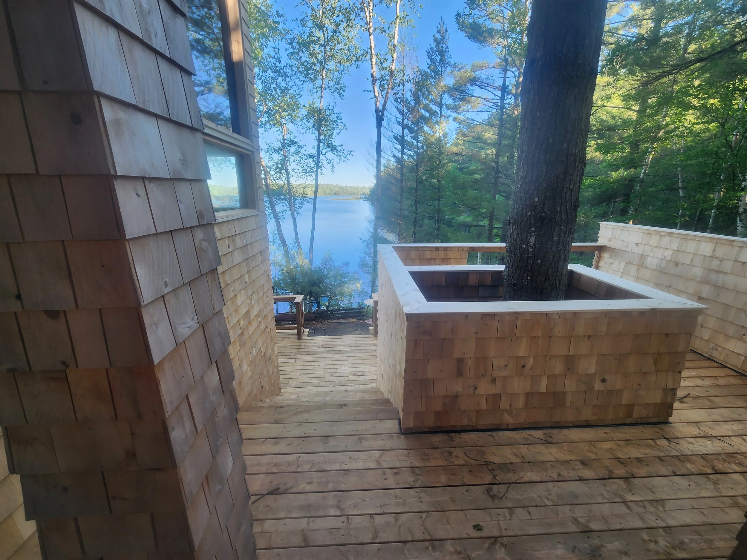 ground-up-constructing-muskoka-deck-cedar-tree-surround-lake-view.jpg
