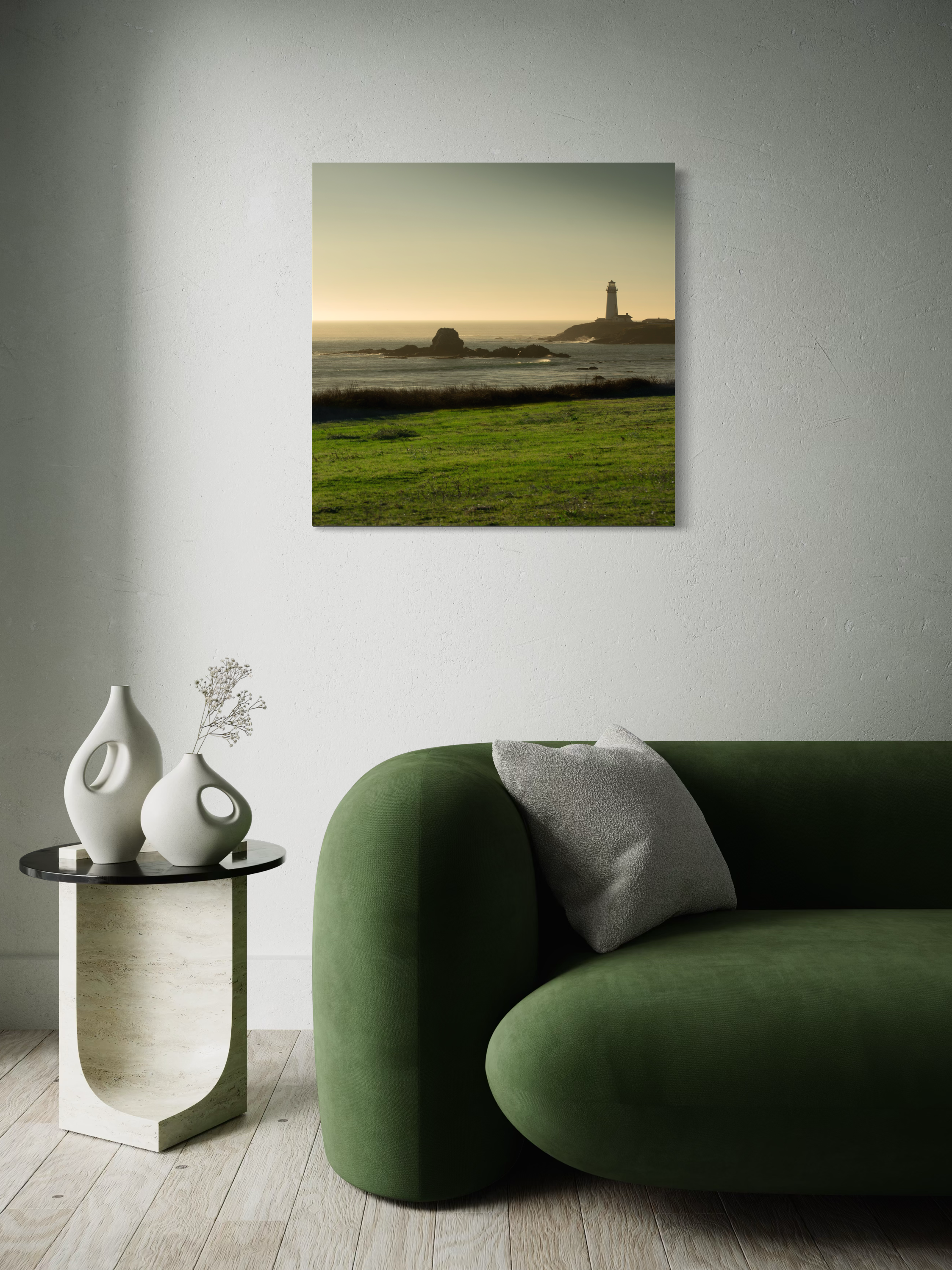 Modern living room with green sofa, abstract art on side table and natural light.