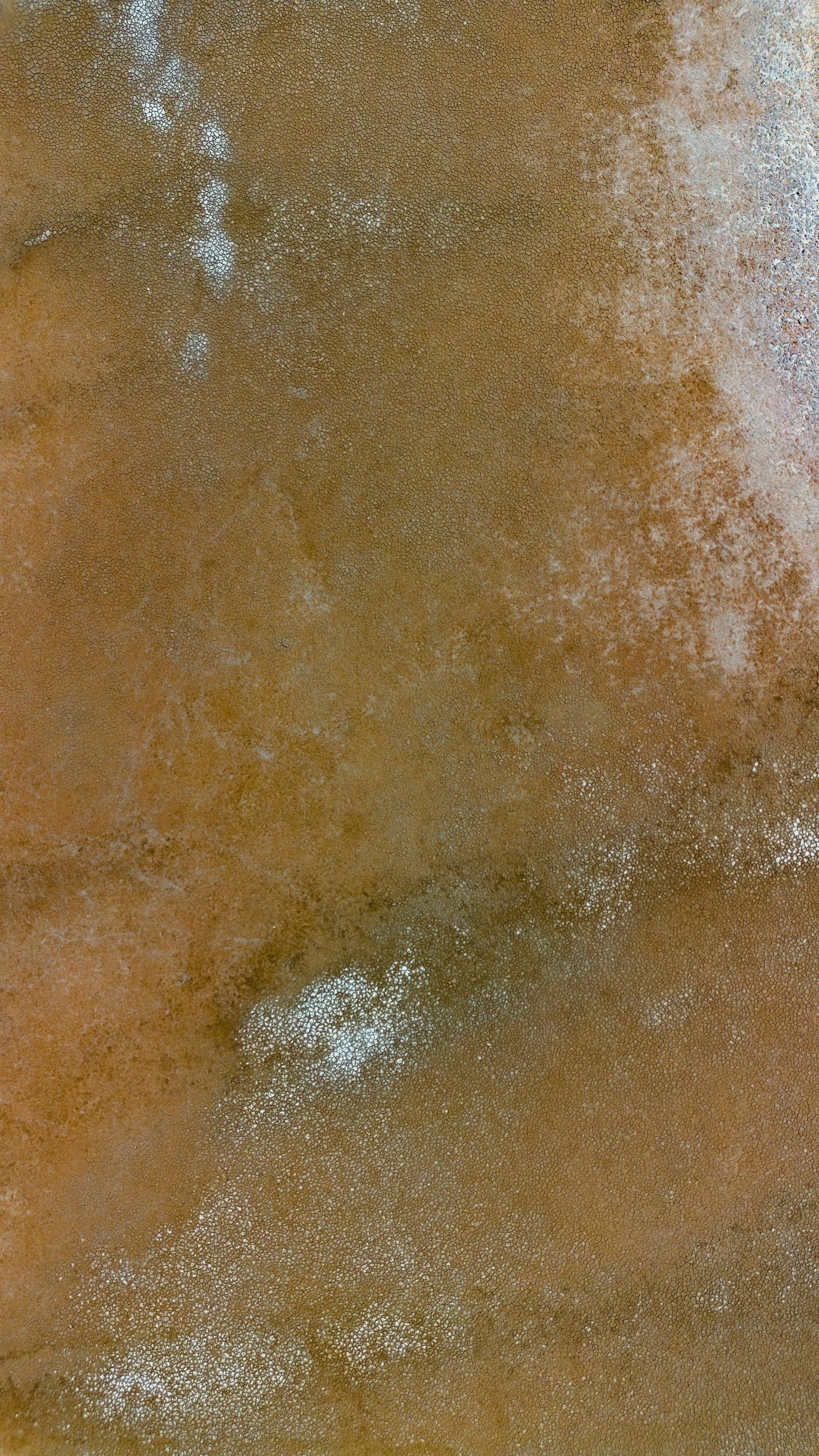 Close-up of a surface with brown and white speckles, possibly a textured or metallic material.
