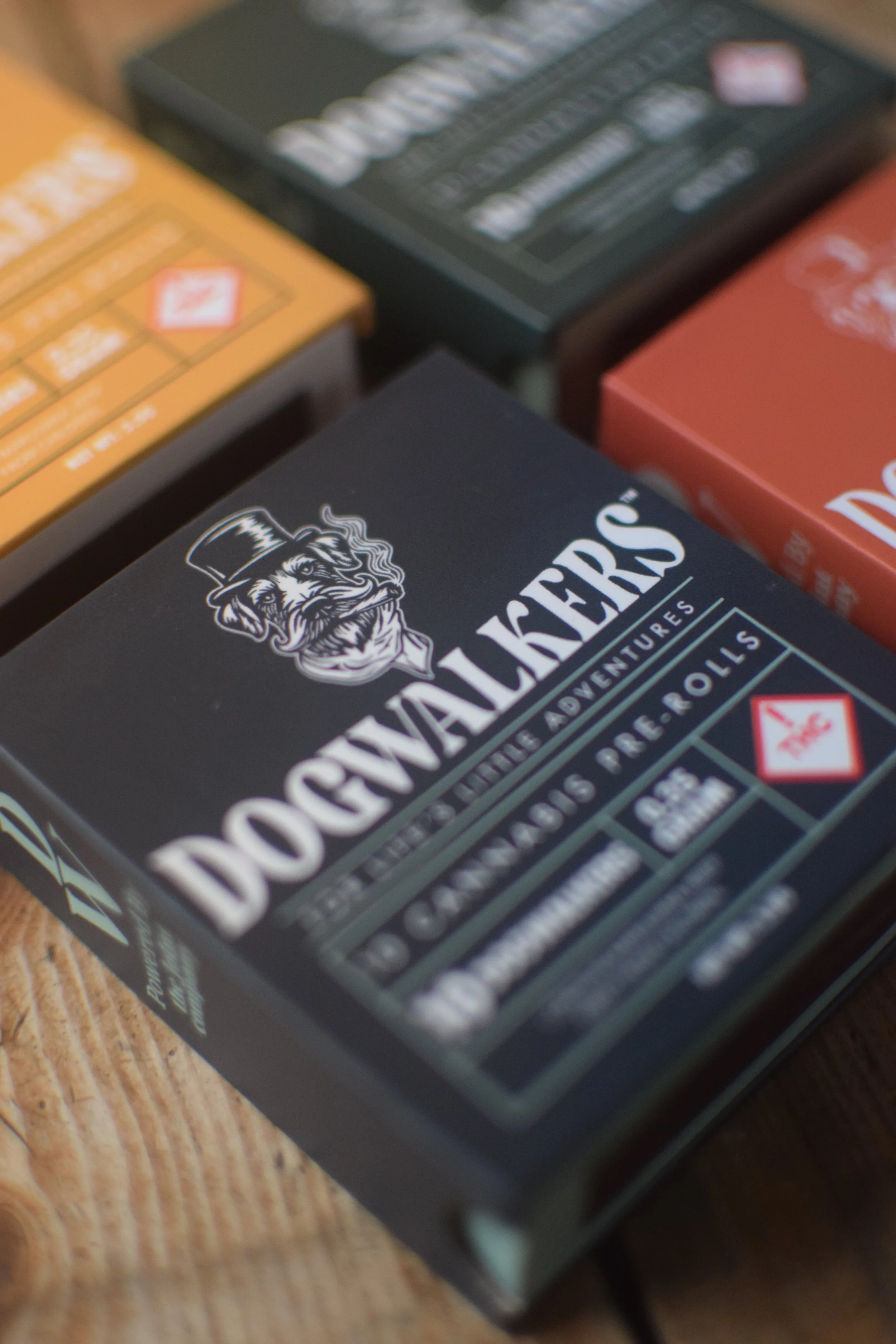 A box of Donvalkers flavored tobacco with a logo of a dog with a top hat and mustache, on a wooden surface.