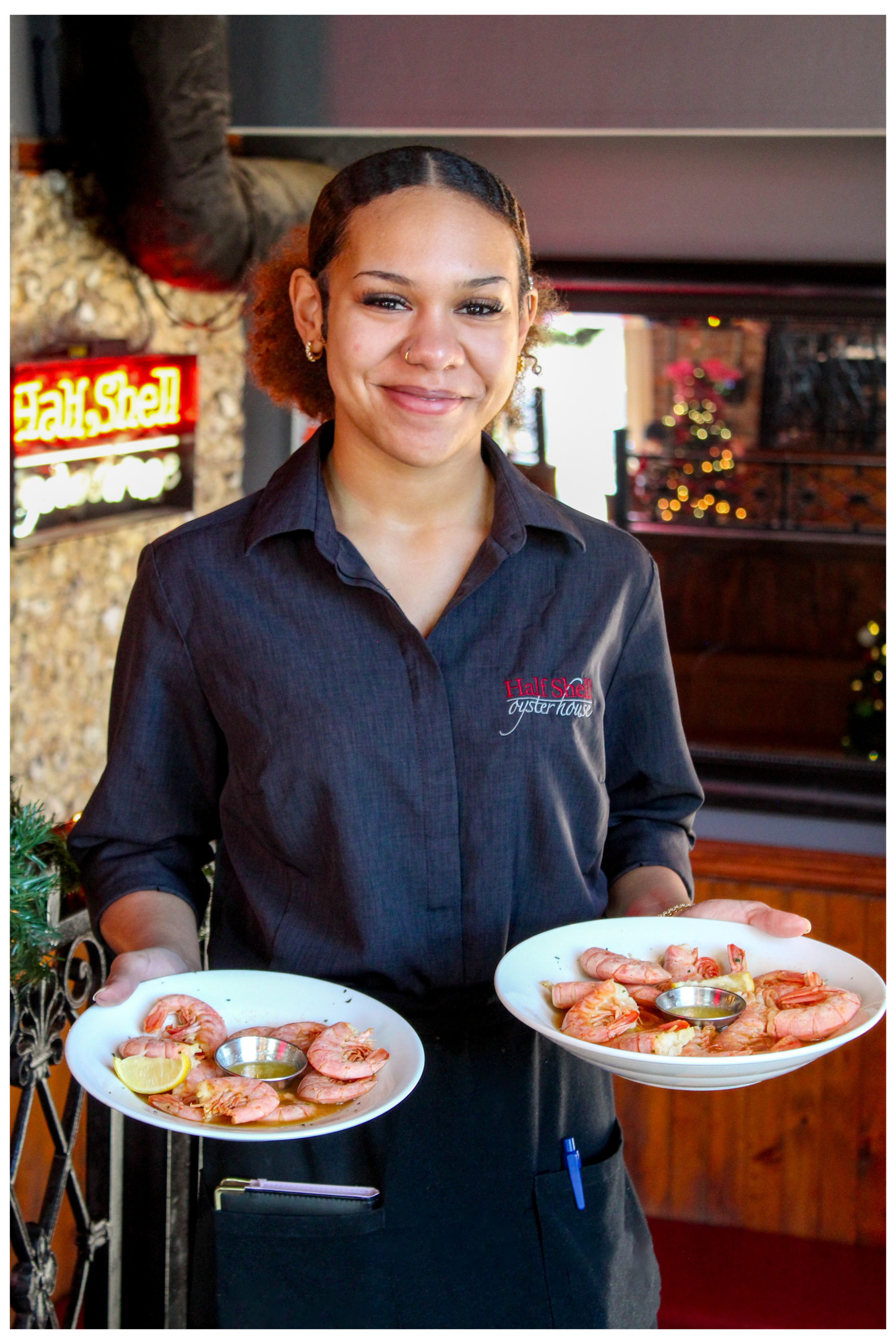 Server holding two plates at Half Shell Oyster House dining room