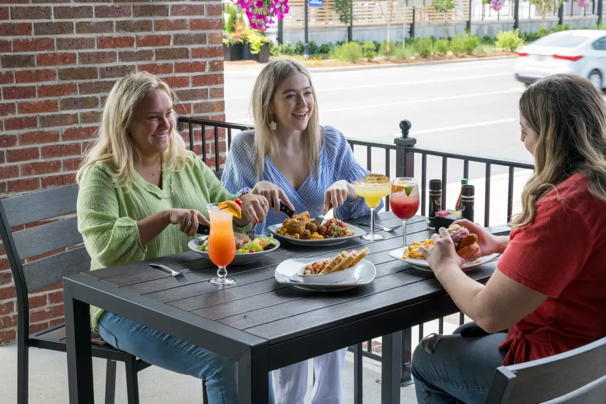 Three girls in their 20's enjoying lunch on the patio at Half Shell Oyster House
