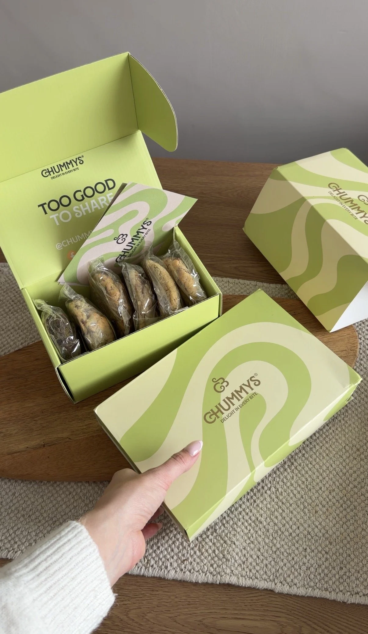 Person holding a box, next to it is an open box of cookies