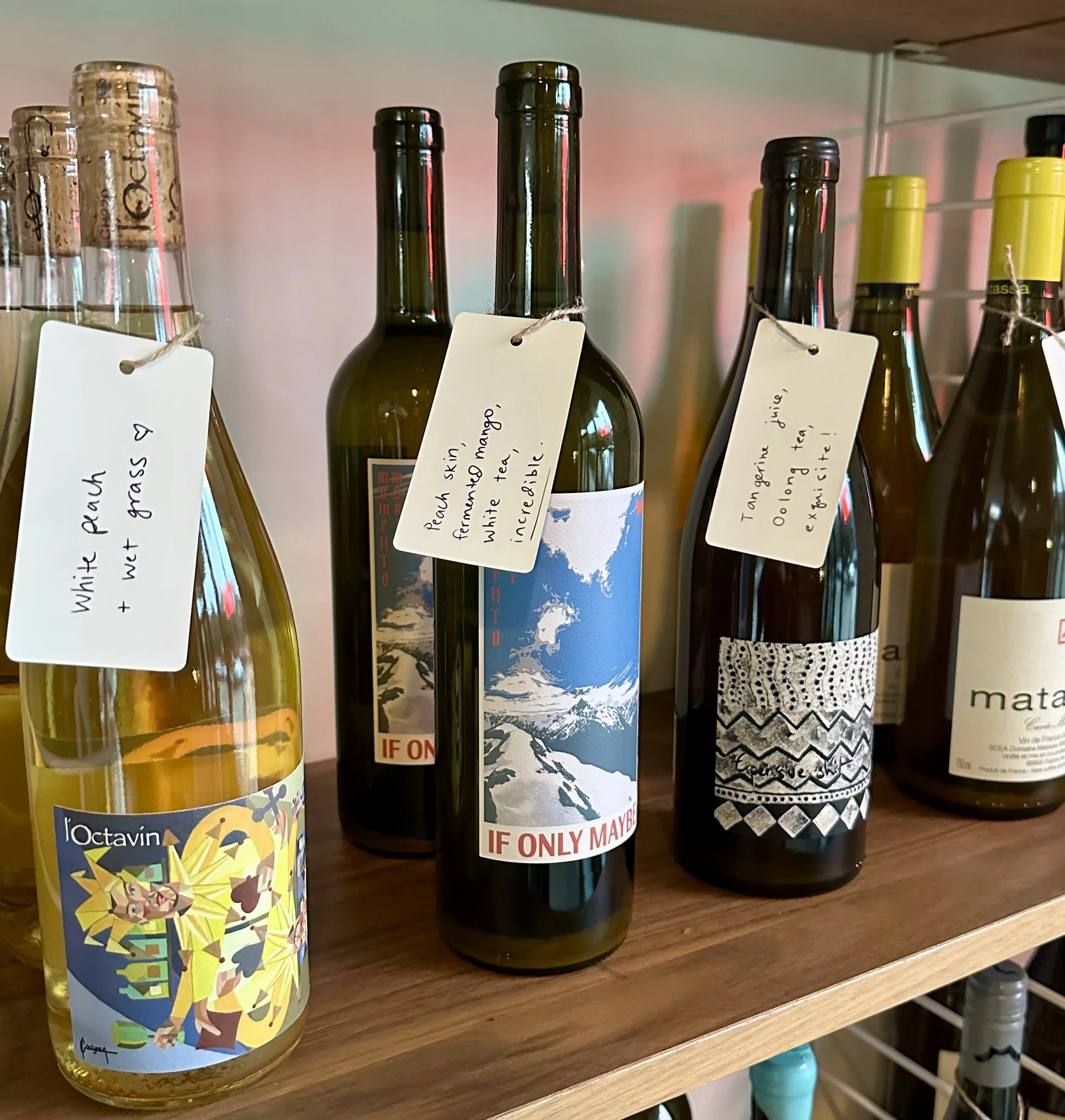 3 bottles of orange wine with tags including tasting notes