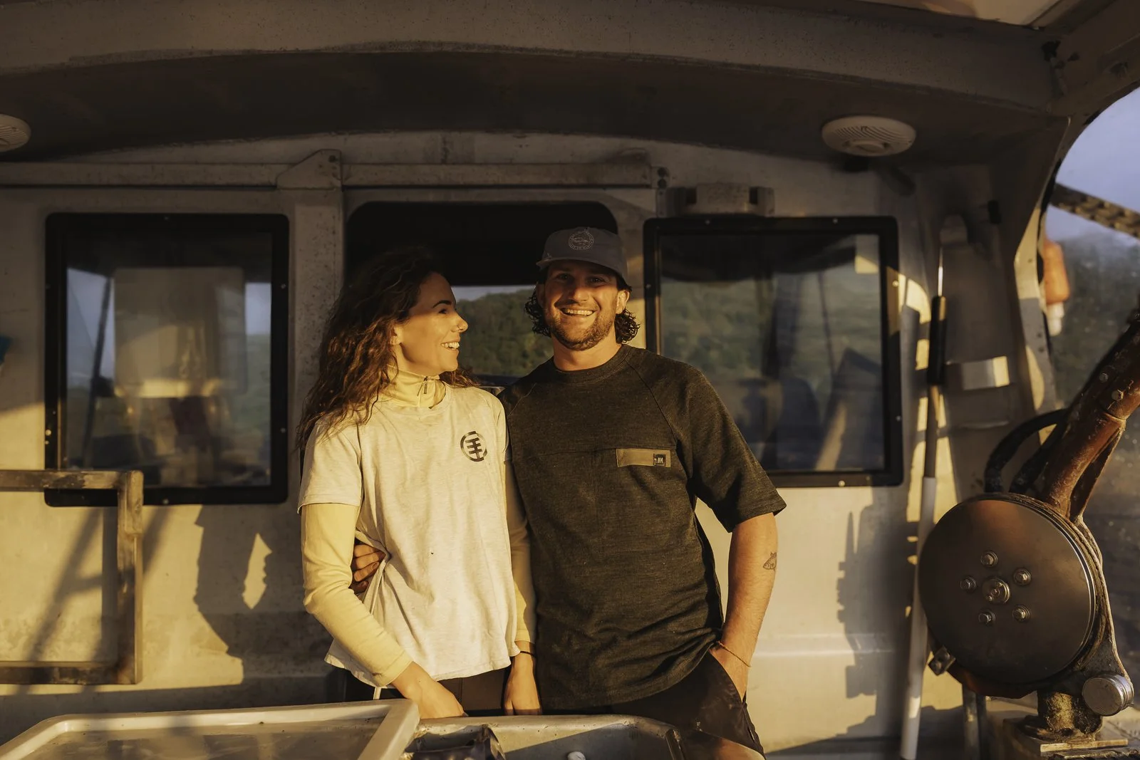 Troy and Claire from Tora Collective at sunset on their boat, Tora coast.