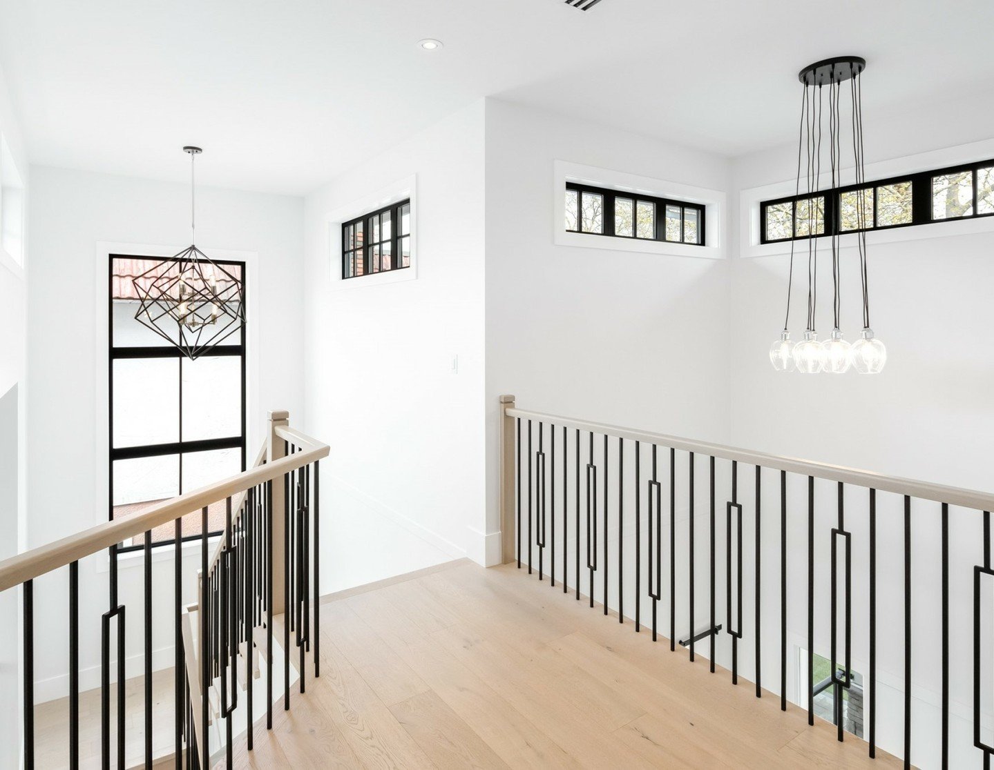 Step into transitional elegance: a bespoke residential project with KFA Homes. 

Striking black railings, bright white walls and wood floors are accentuated by feature pendants and framed by sunlit windows 🪟☀️
.
.
.
.
.
.
#interiordesign #design #st