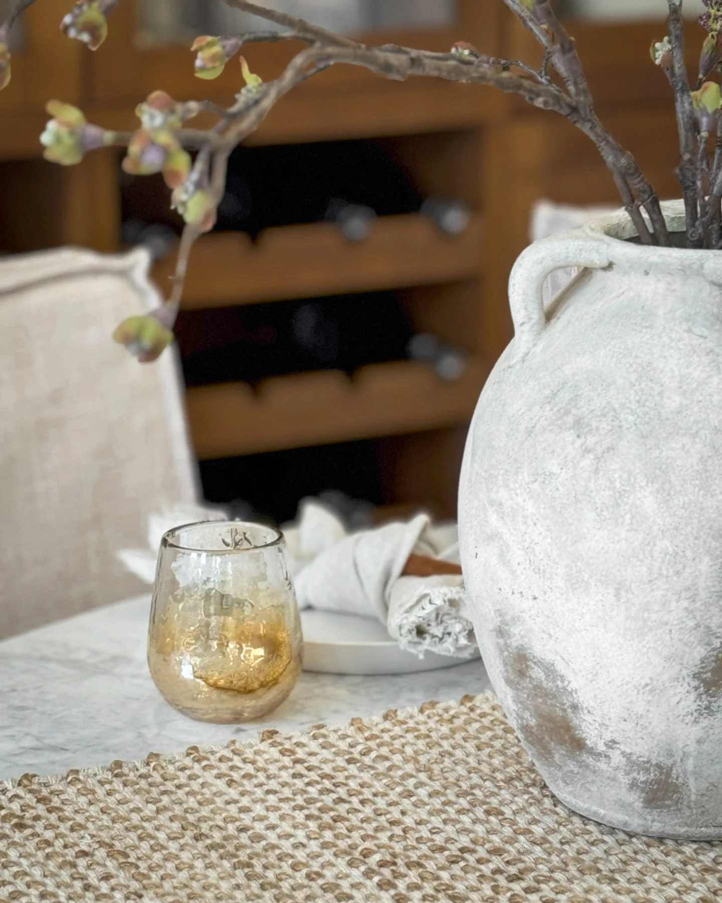 Fall, interpreted through texture.

Woven fibres, aged stone, warm metallics, and branches gathered just before the turn of the season bring a softer richness to the table. The palette remains restrained, but the mood shifts entirely.

Quietly layere