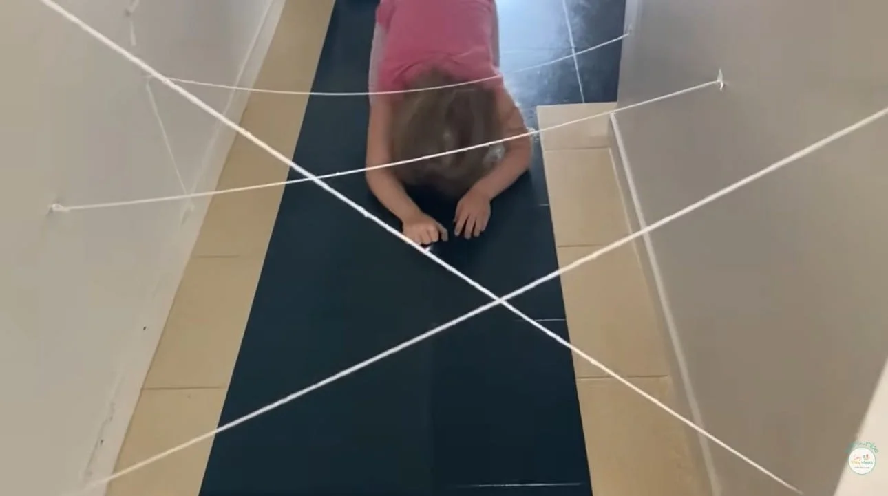 Child crawling under string maze