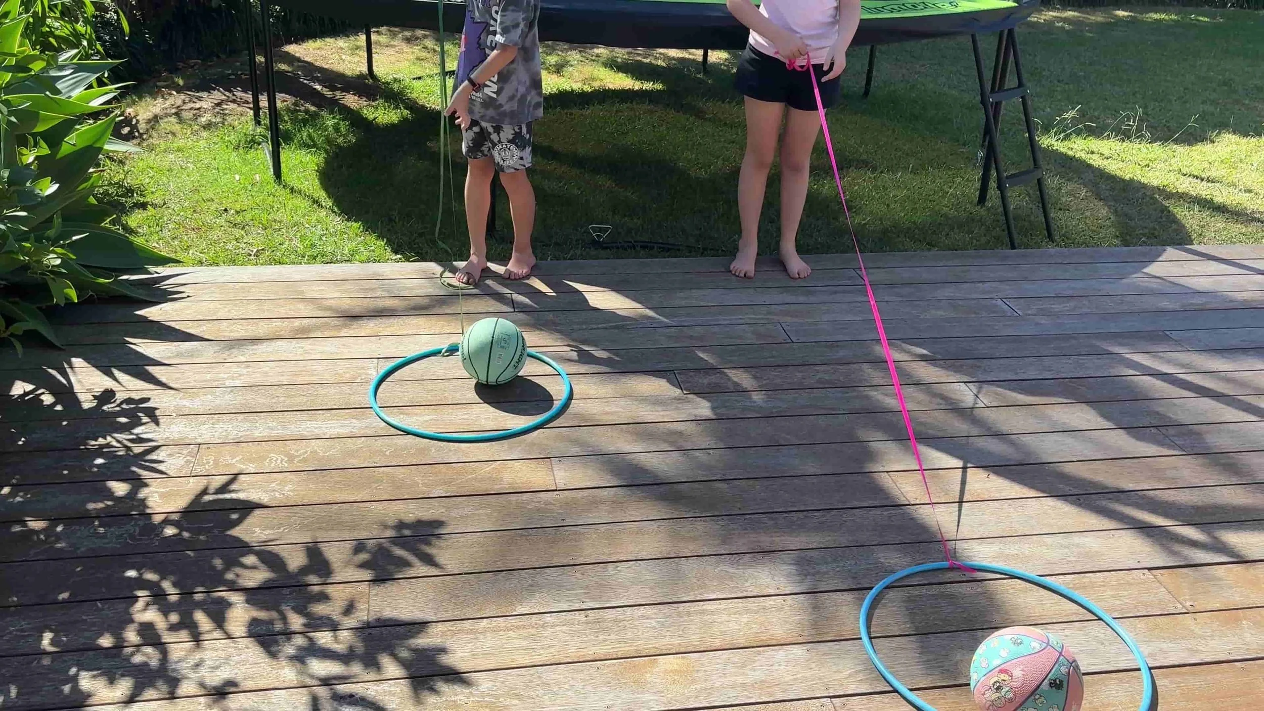 Children pulling ribbon and hoops with balls in them