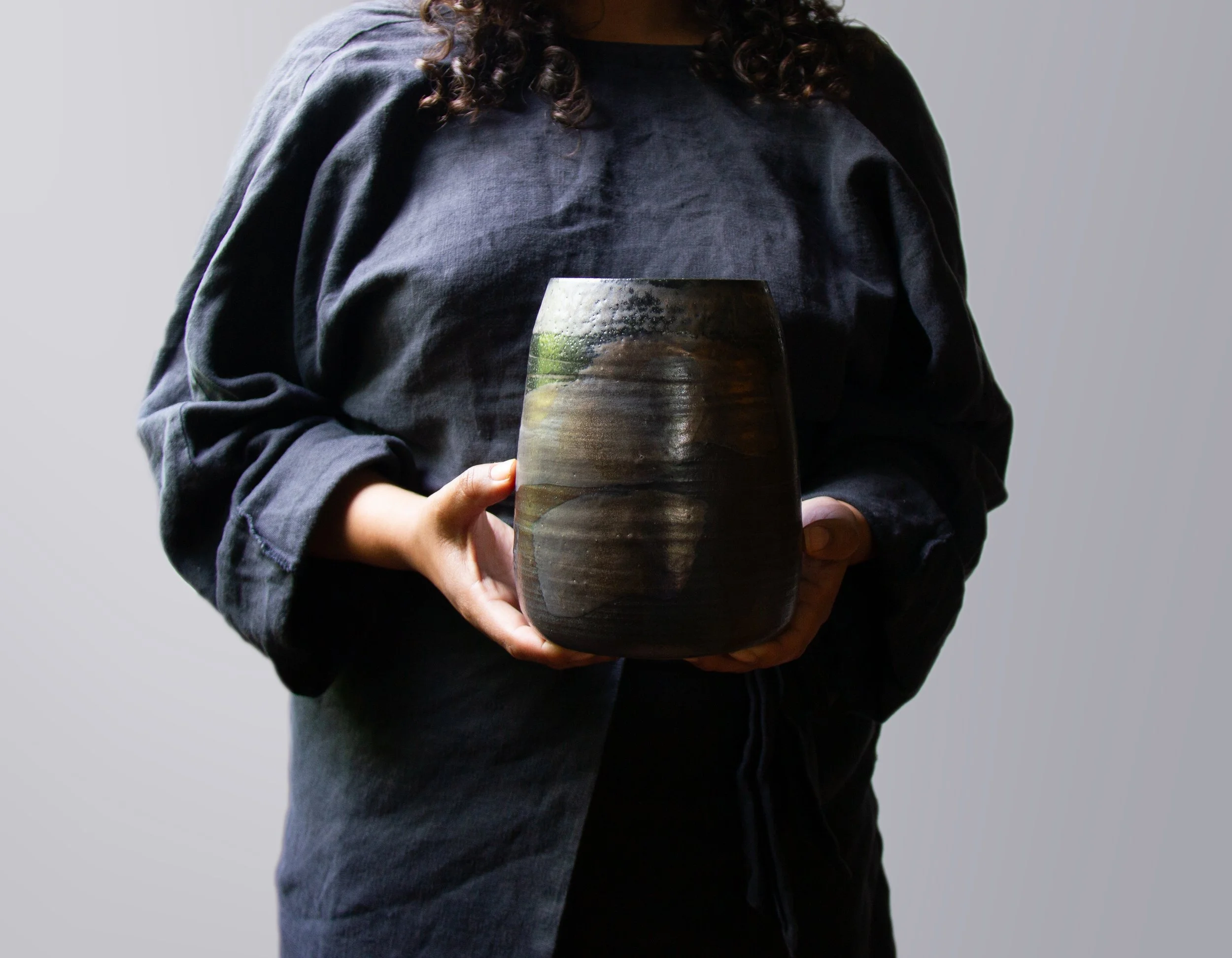 hands holding a handmade pottery vase
