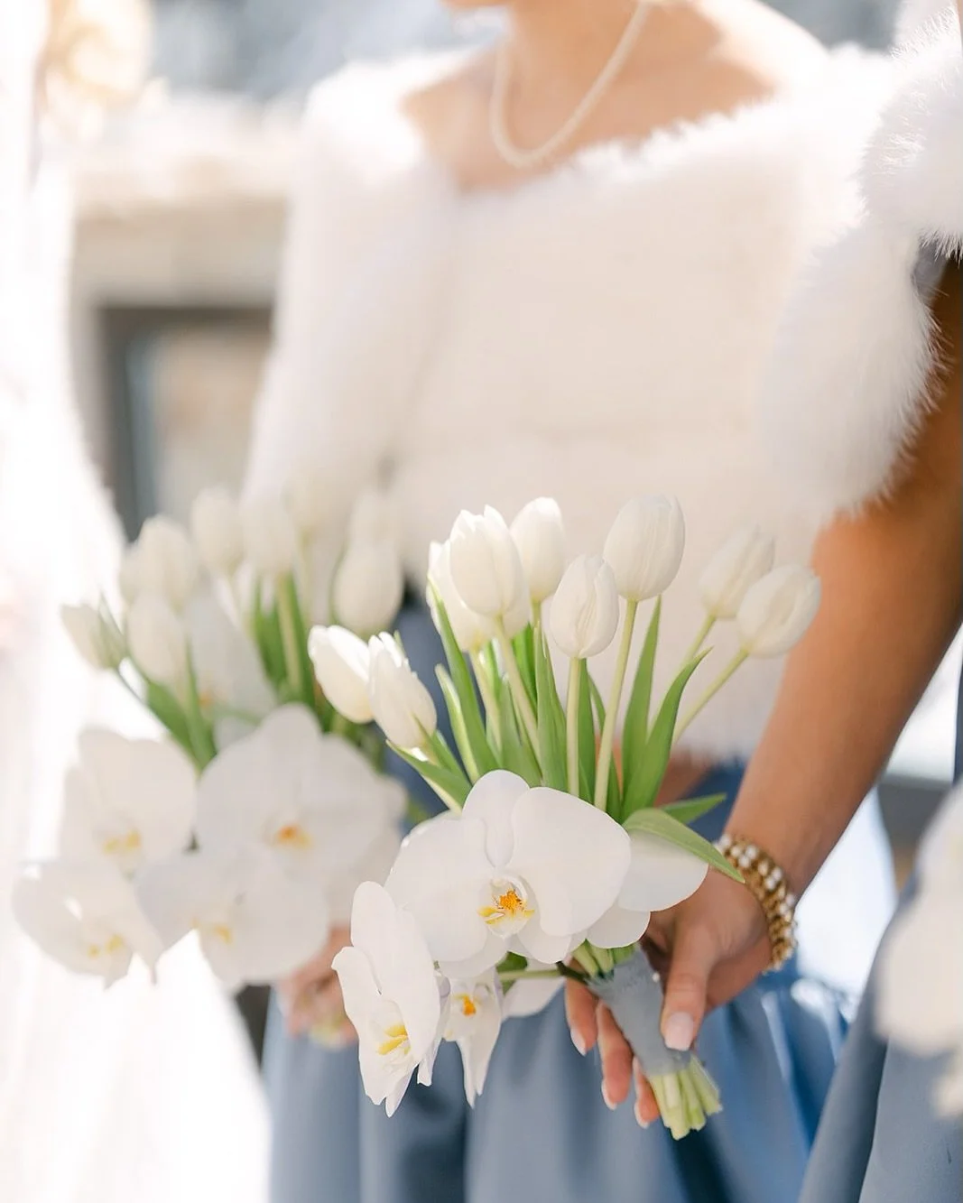 Chic, classic, and perfectly seasonal ❄️ Haley&rsquo;s bridesmaids brought winter elegance to life with icy blue dresses, soft fur stoles, and the dreamiest white tulip + orchid bouquets. We loved every detail of this late March wedding at the stunni