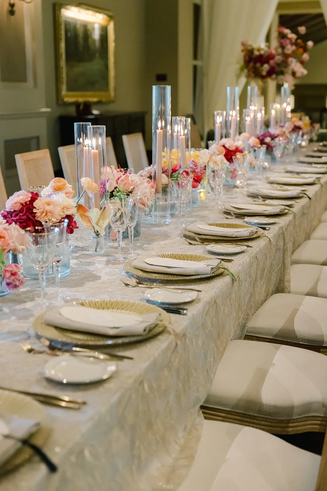 Long reception table with lush floral arrangements, glass cylinder candles, and elegant place settings in the Vista Lounge at Montage Deer Valley, designed by Duet Weddings and Events