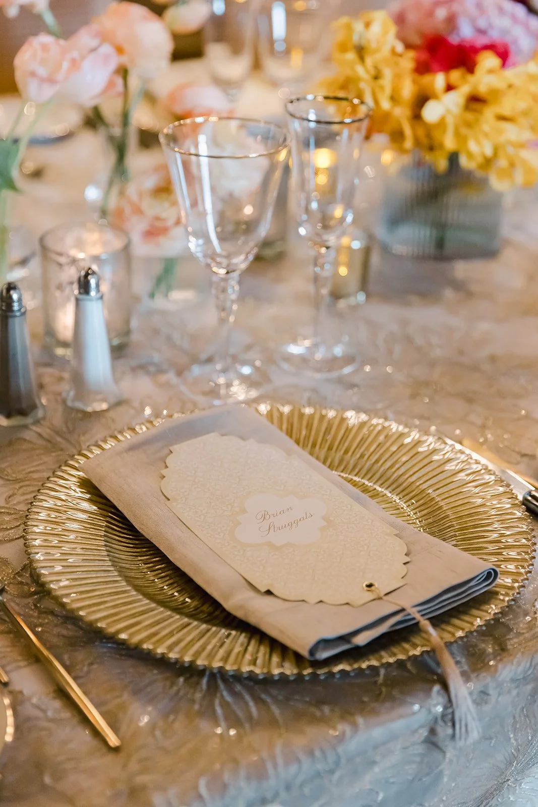 Elegant plated dinner table setting with gold charger, menu card, and soft floral accents in the Vista Lounge at Montage Deer Valley, planned by Duet Weddings and Events