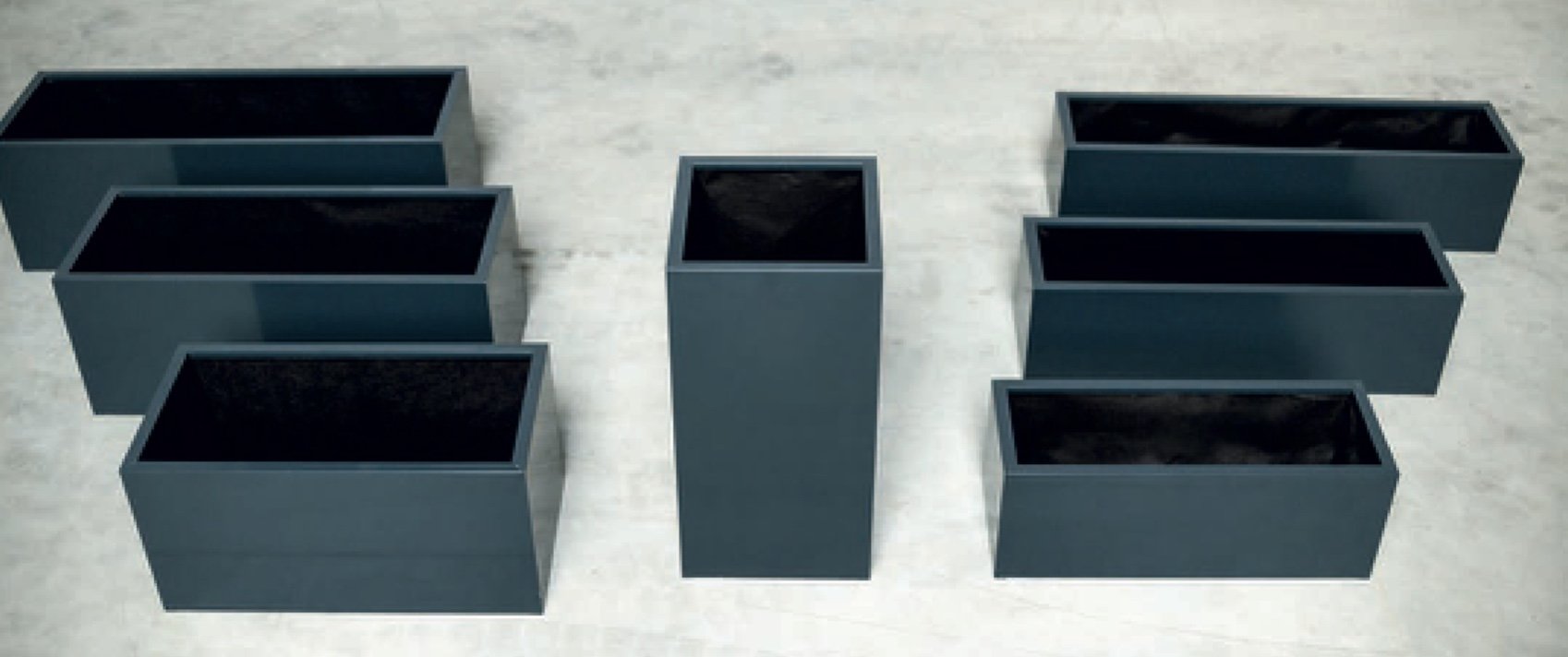 Sju gråa metall palneteringskärl, sex ligger på sidan och en står upp.