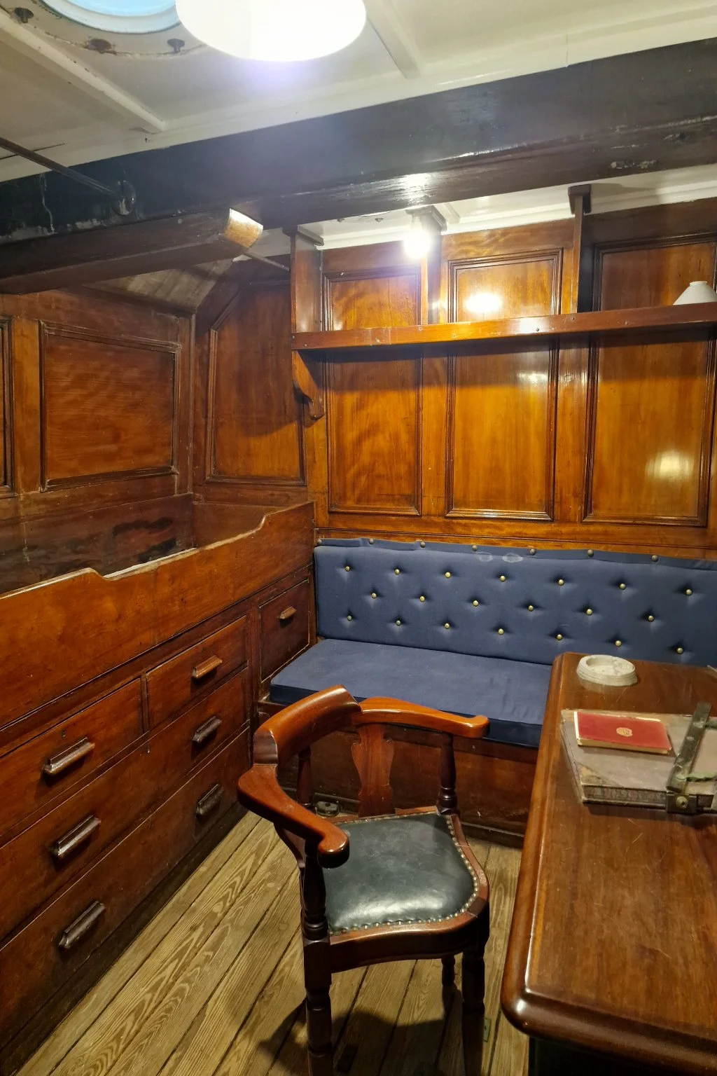An example of an ordinary officer's cabin: a cabin bed, narrow sofa, desk, and chair. All, including the wall panels, in polished wood.