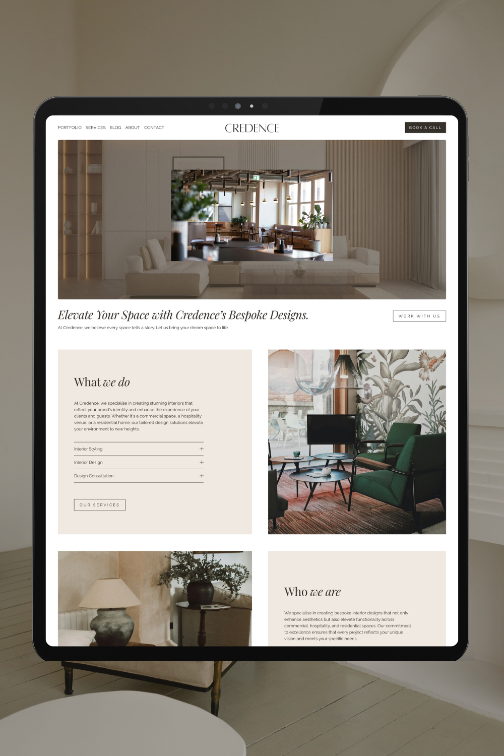 A digital tablet displaying a website for an interior design company called Credence, featuring images of modern interior spaces and descriptions of their services.