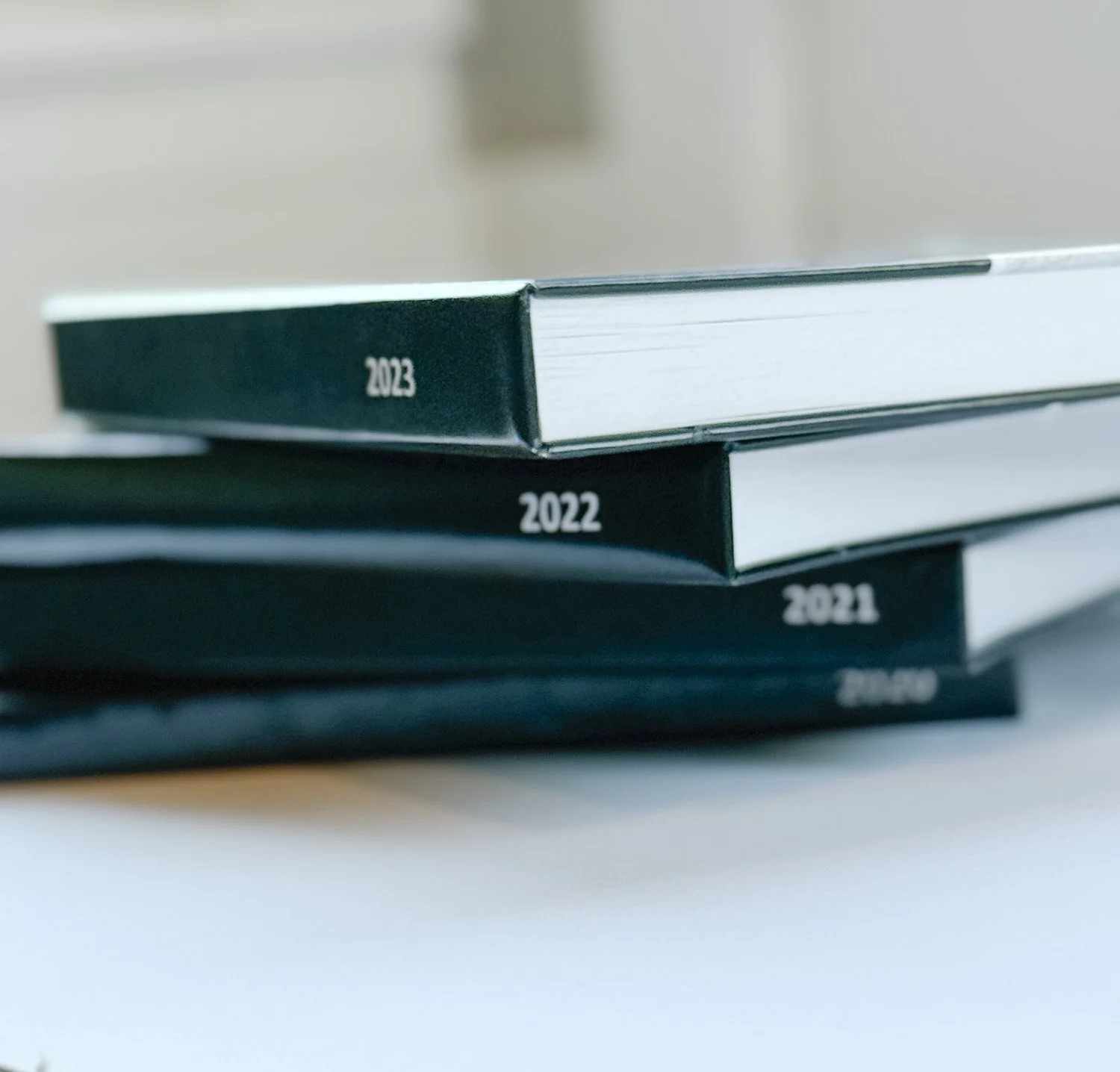 A stack of family photo books with the years 2021, 2022, and 2023.