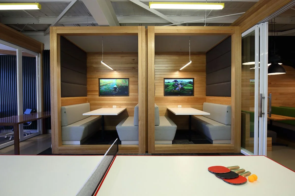 Hocking Stuart ping pong table and two private booths in the background. Wood and light grey look.