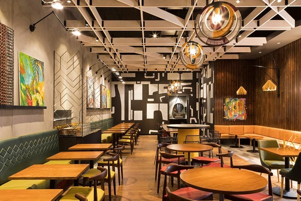 Nando's dinning area with art on the walls and a large abstract black and white mural in the back wall