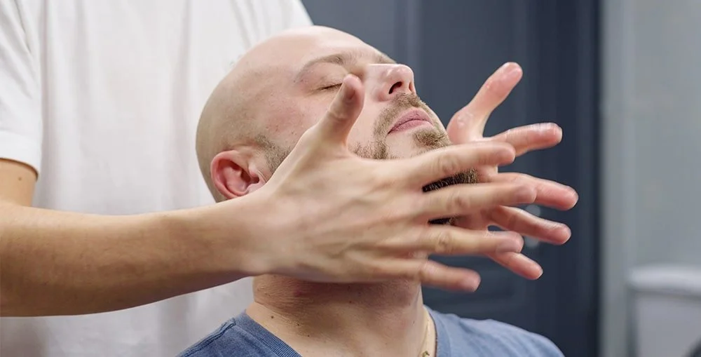 Registered massage therapist treating client’s neck tension from whiplash injury at West End Wellness clinic in Vancouver.