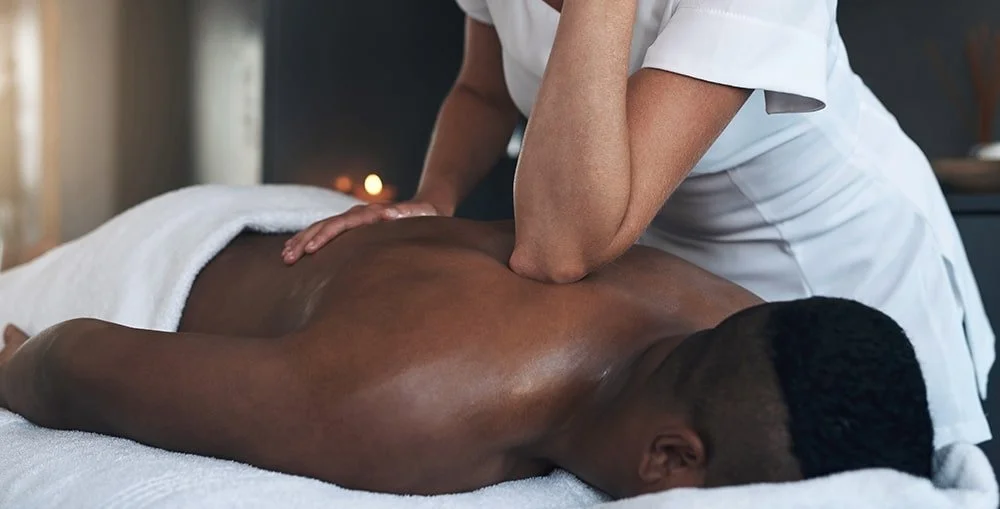 Massage therapist assessing client’s leg mobility, reflecting professional growth and practical training for RMT students in BC.