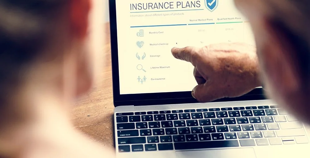 Person reviewing ICBC insurance plans on laptop, understanding coverage options after a car accident in Vancouver.