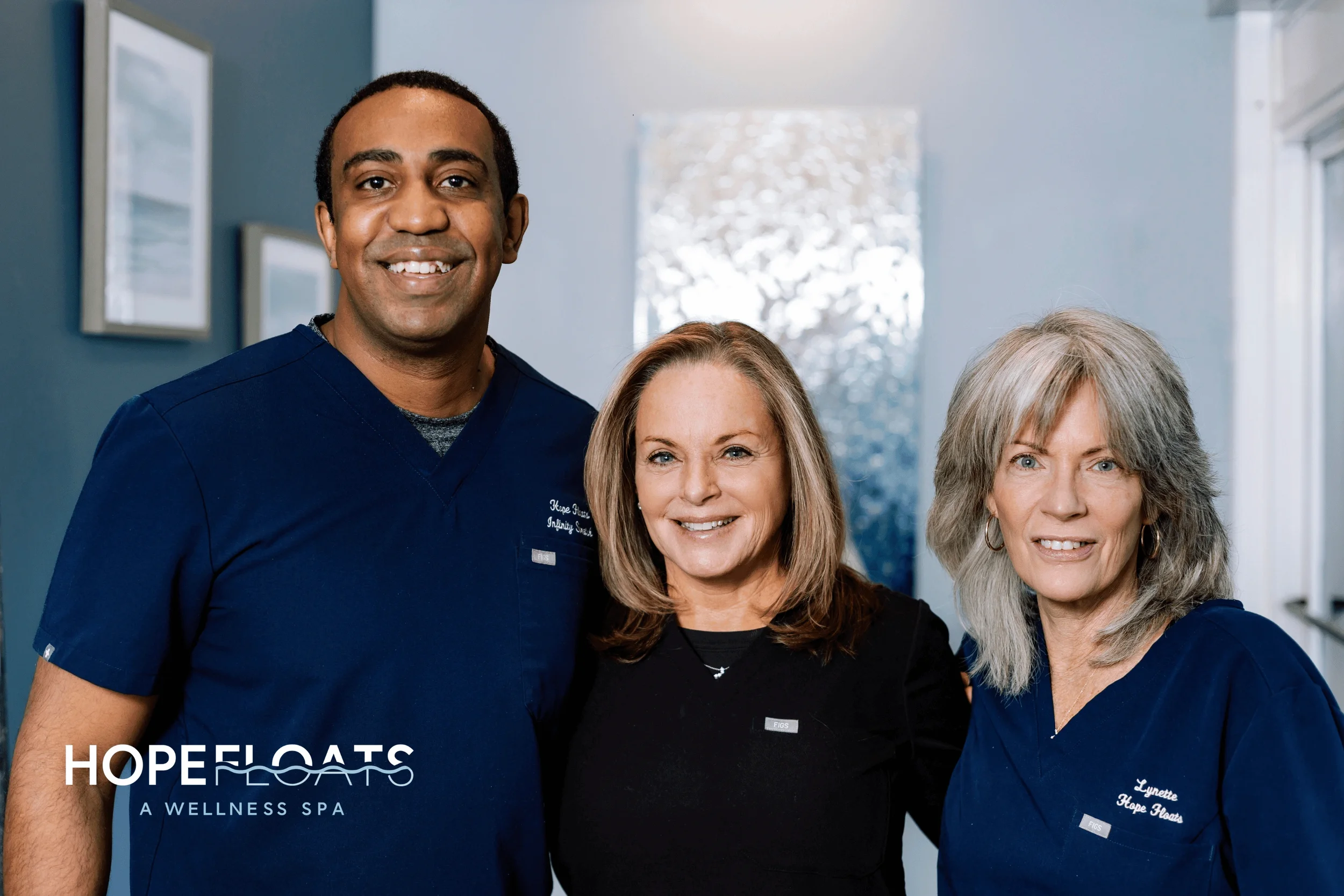 A man and two women standing together, smiling