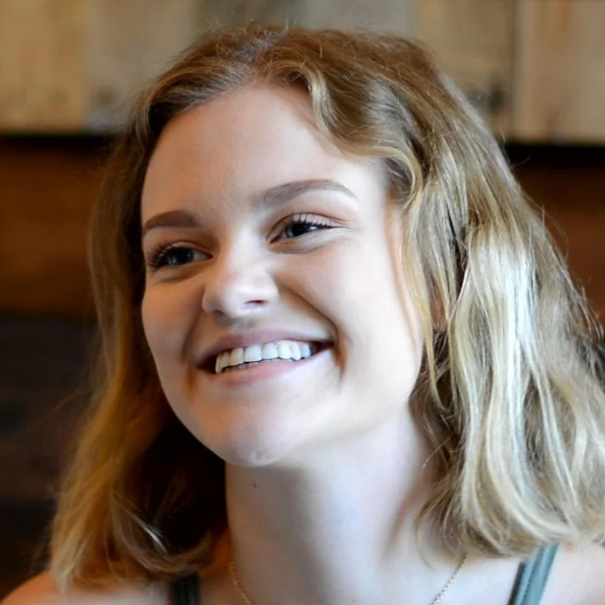 Smiling woman with blonde hair and a light background.