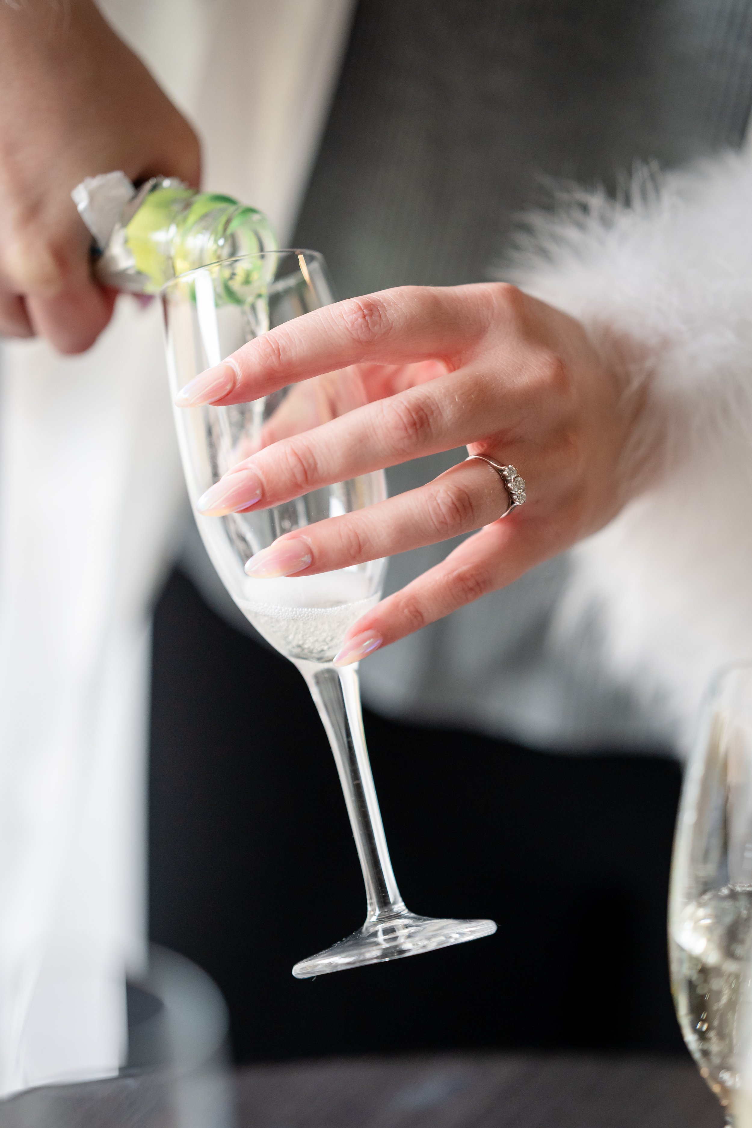 Champagne being poured into a glass held by the bride, her wedding ring visible, at the Brassey Hotel in Canberra