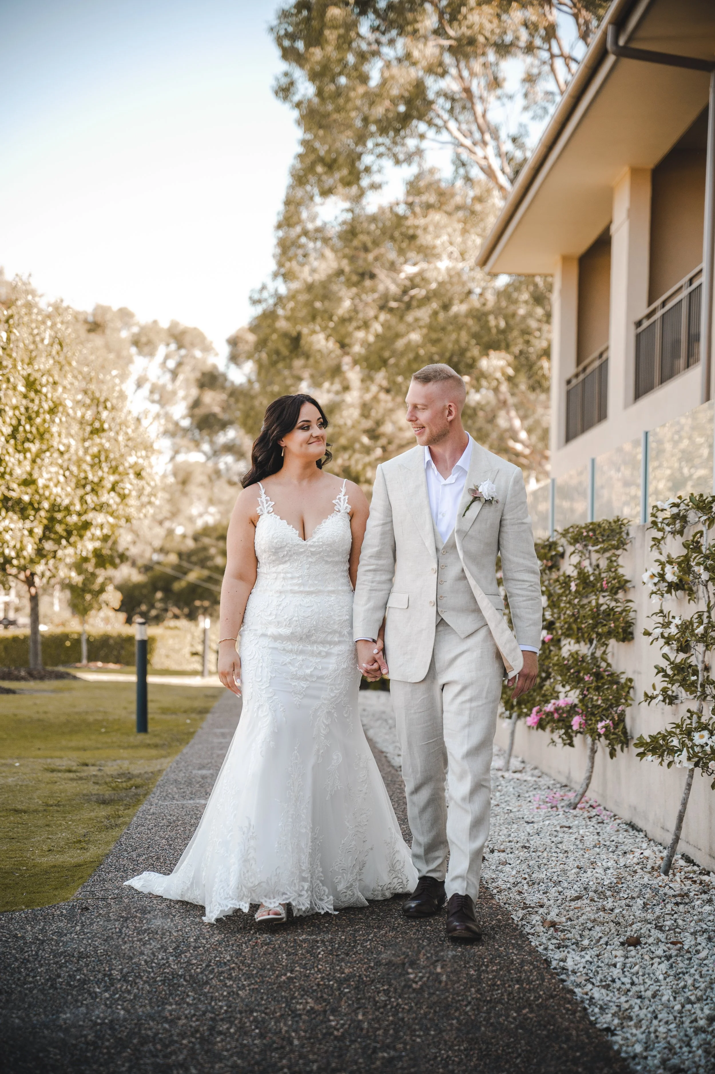 Bride and groom walk hand in hand along a petal strewn path at Château Élan in the Hunter Valley