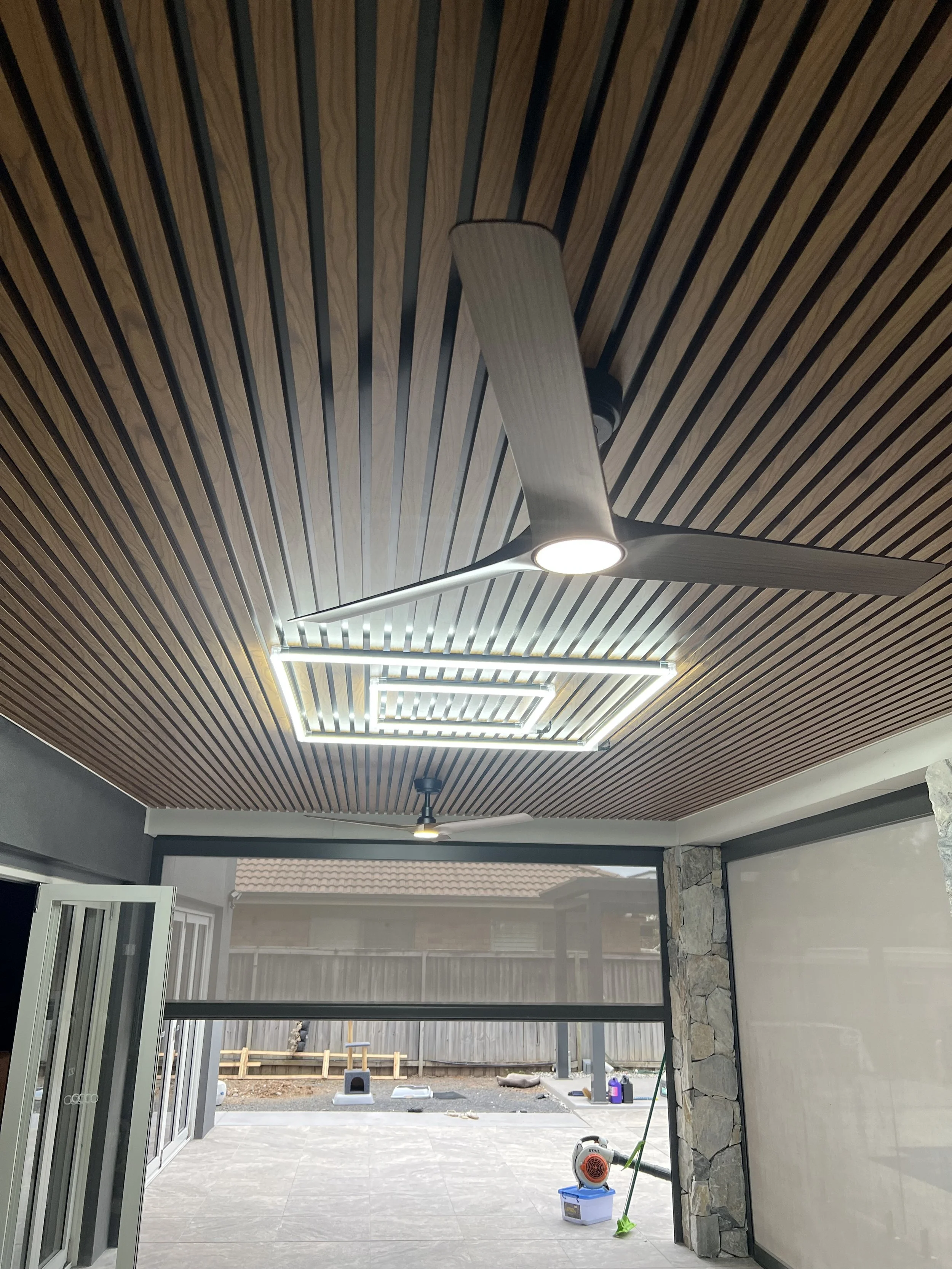Indoor patio with a ceiling fan and linear ceiling lights.