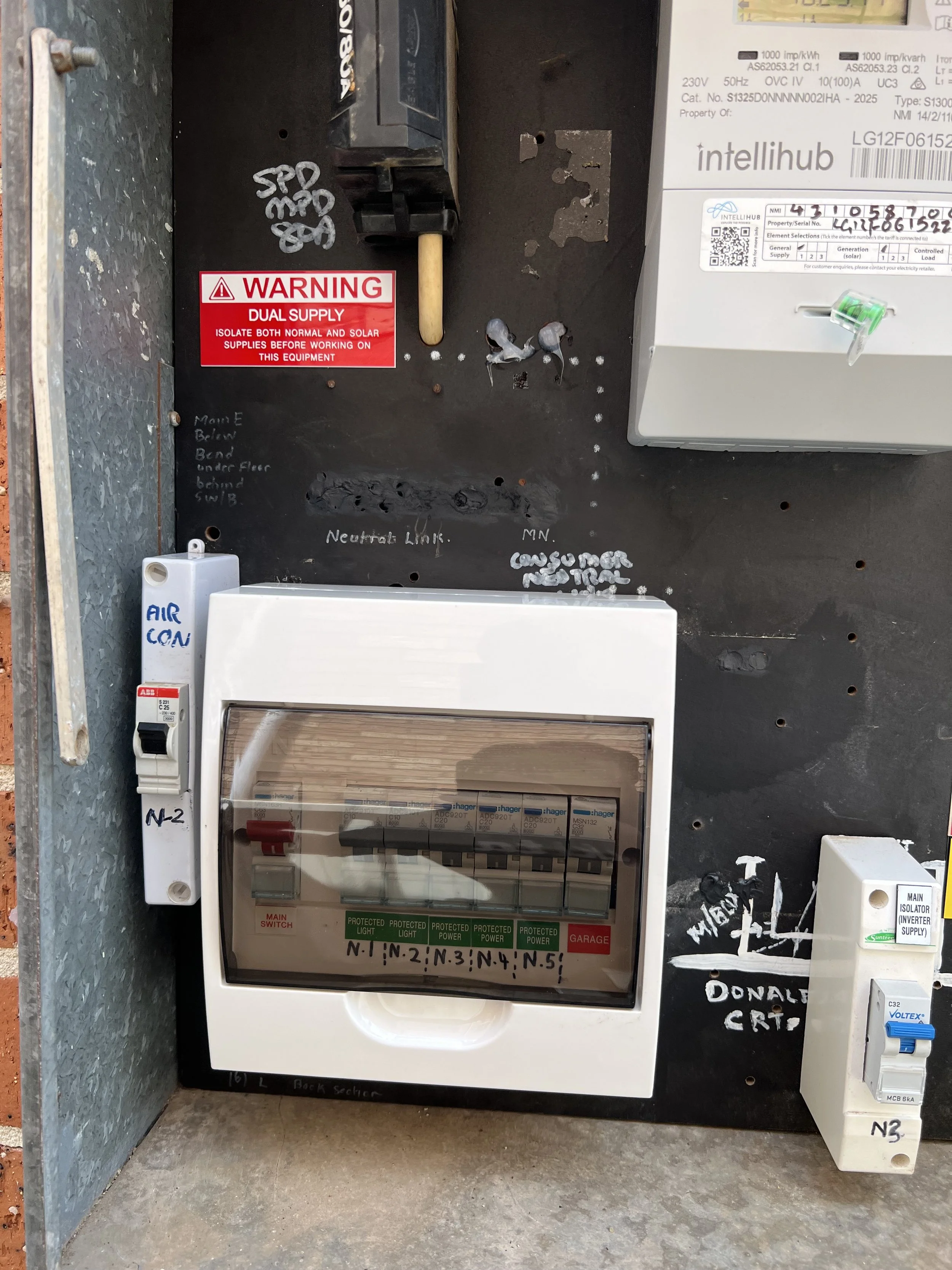 Electrical switchboard with rcd mounted on a black board wall, with wires and labels surrounding it. Switchboard upgrade for a customers house in rosemeadow