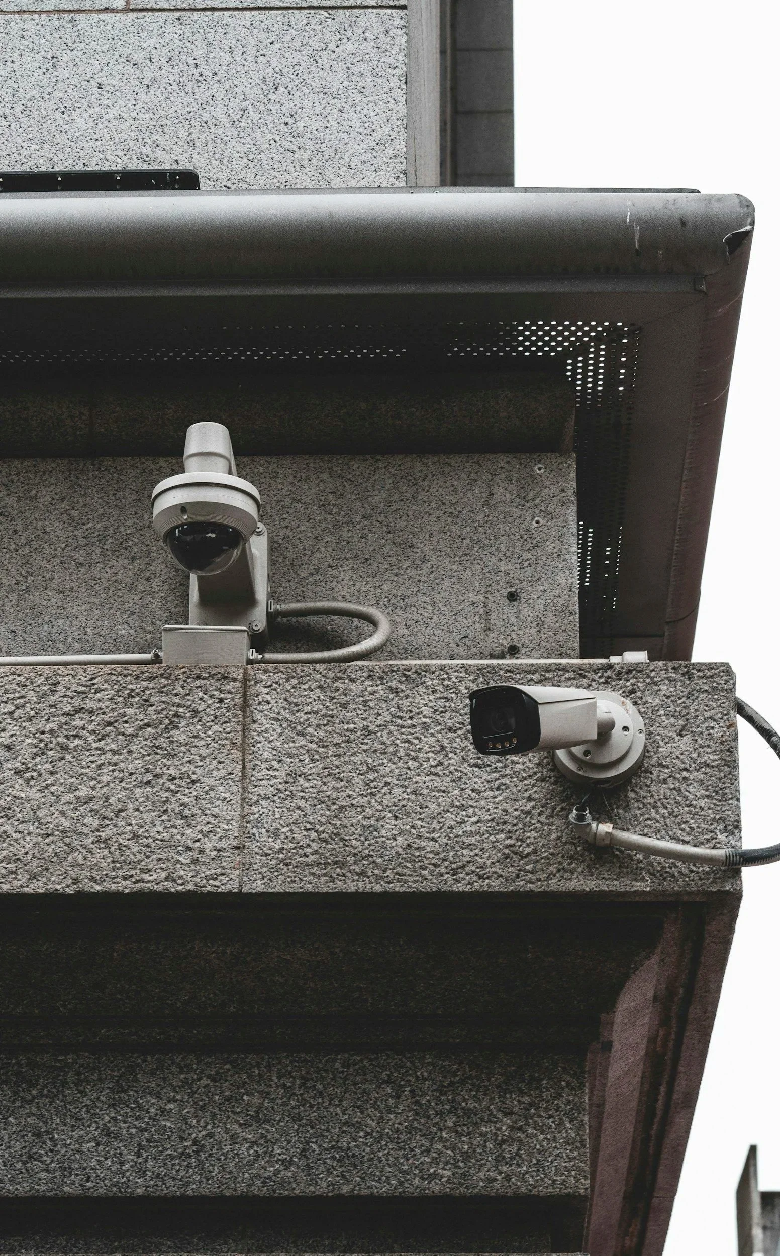 Security cameras mounted on the corner of a building's exterior wall.