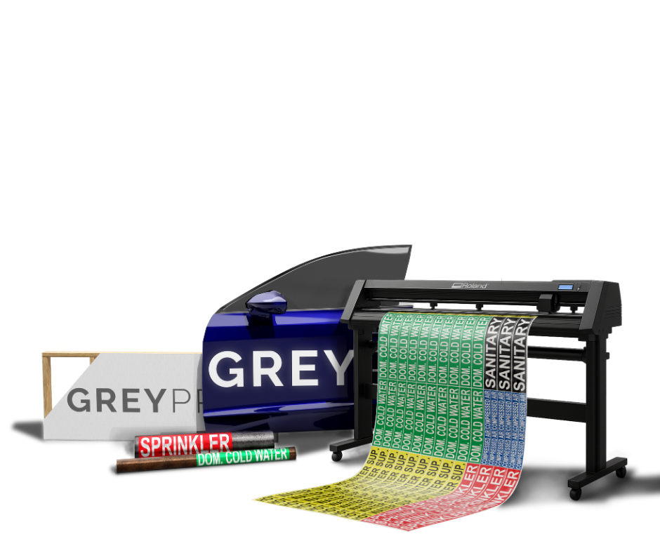 A large printer producing multi-colored labels with text like 'COLD WATER' and 'SANITARY,' alongside rolls of labels and markers for printing and dispensing.