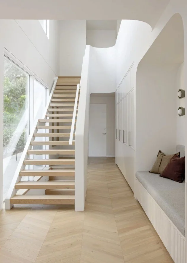 Home entry with timber staircase, built-in bench seat and full wall of storage