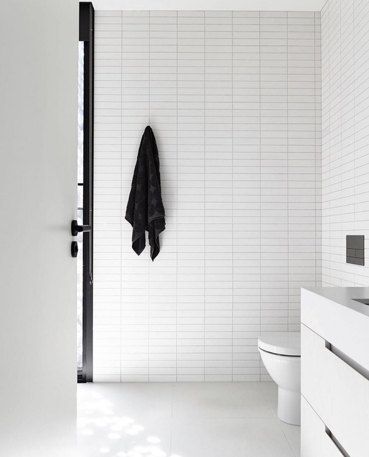 White bathroom kitkat tiles with a straight pattern are installed horizontally for a minimal bathroom design