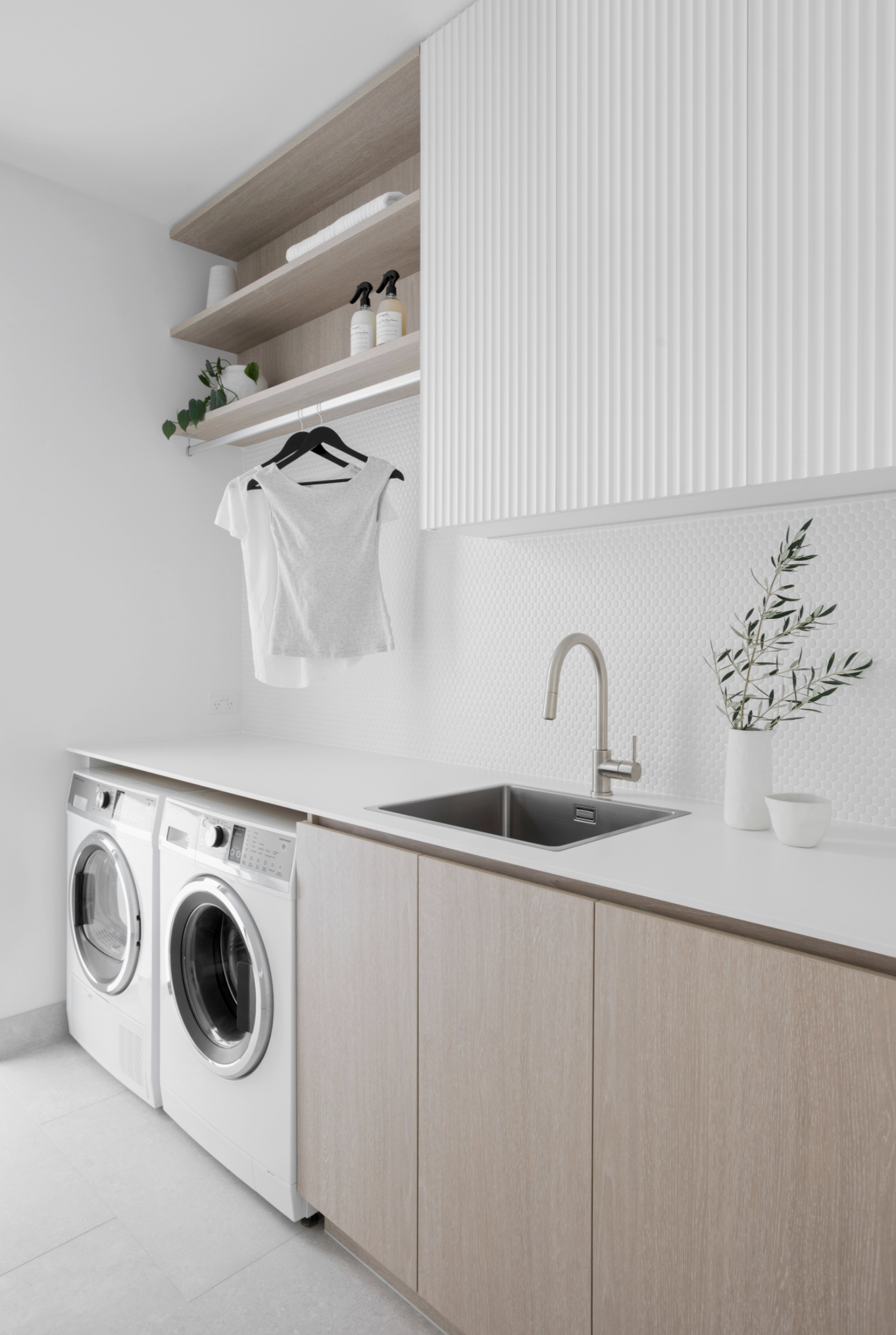 White laundry room design with two machine and wooden laundry cabinets in cotemporary home design guide for laundry renovation