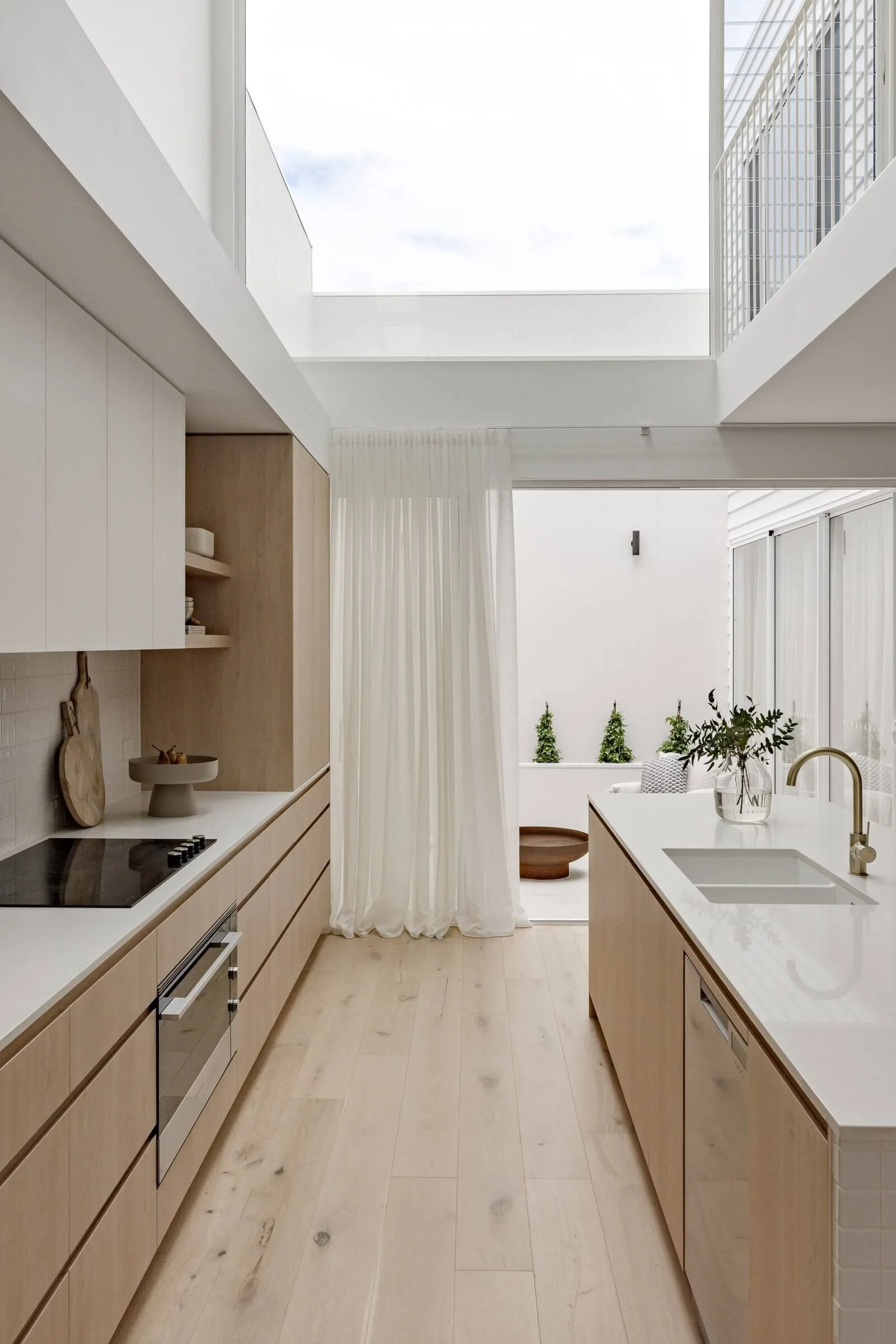 White kitchen island bench design with engineered wooden flooring