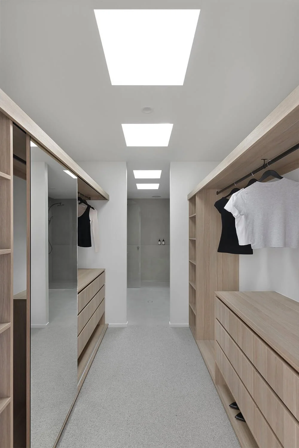Walk in wardrobe with built in cabinets hoined with a bathroom