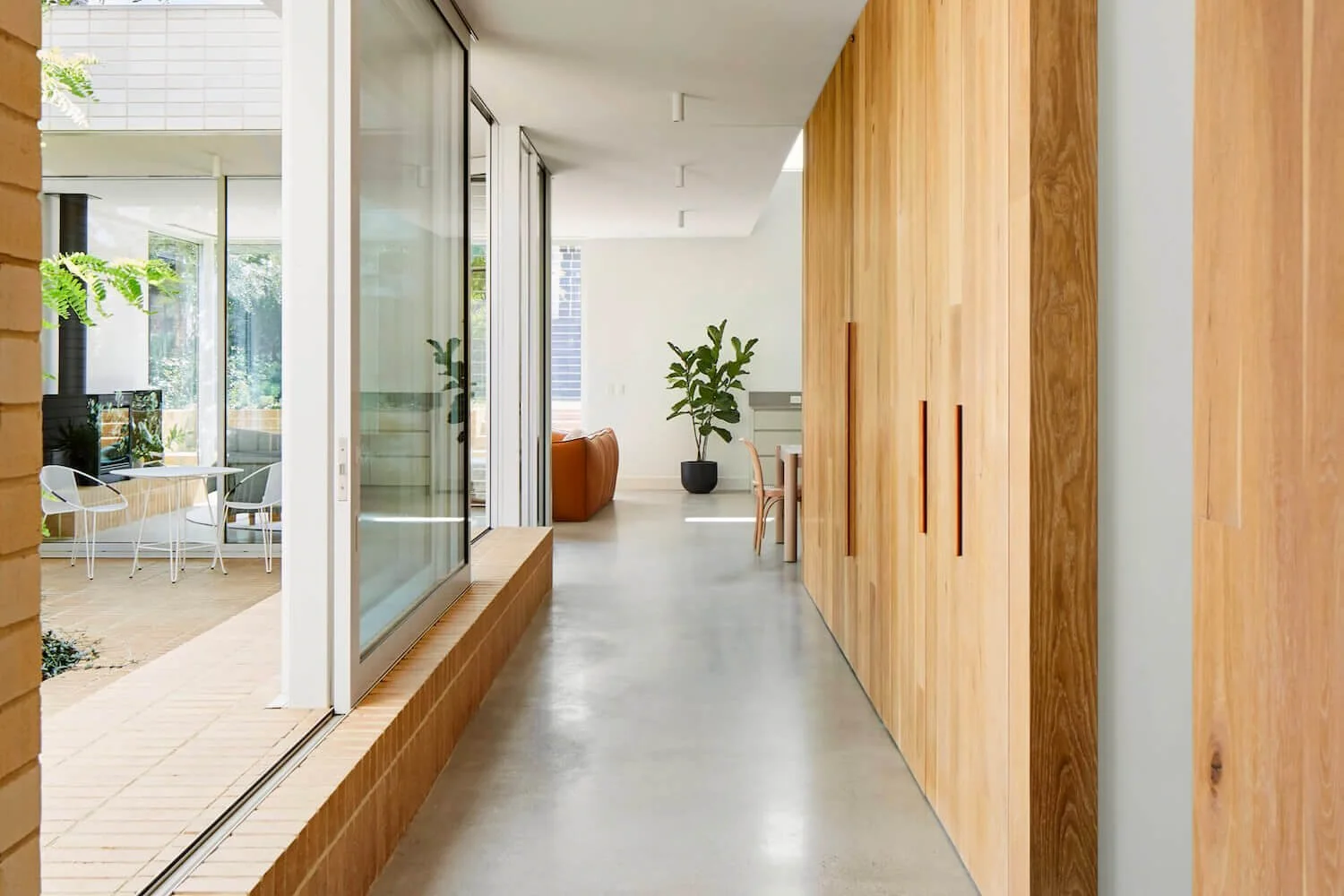 Wide hallway with wooden cupboards and large windows