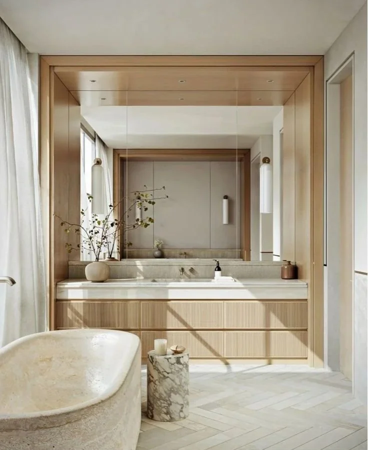 Ensuite vanity with wall lights either side of a timber framed mirror feature