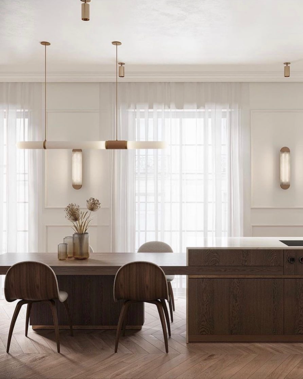 Dark timber dining table at dining height attached to a timber kitchen island bench, with curved dining chairs