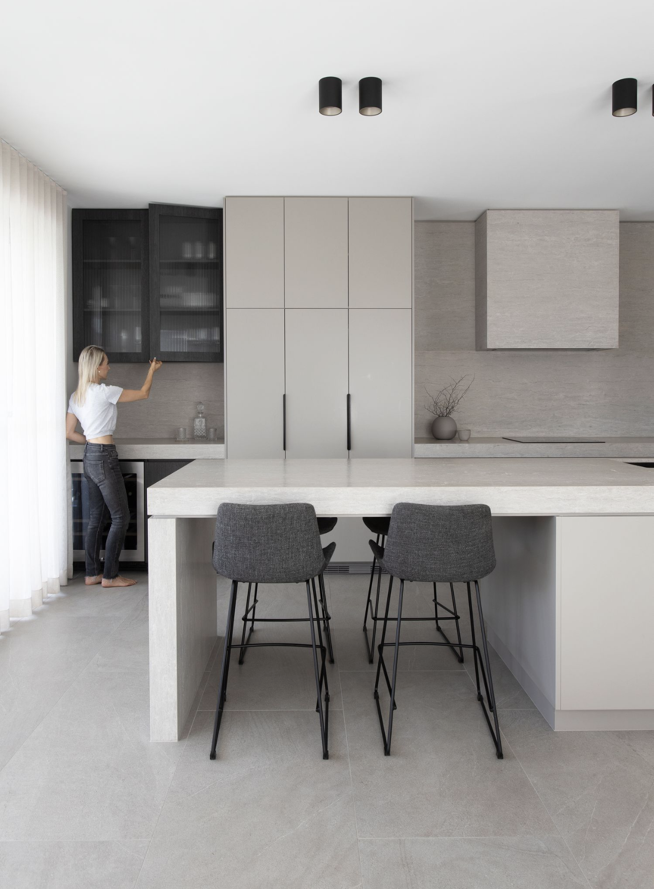 Stone kitchen island bench with seating at the end and stools on both sides