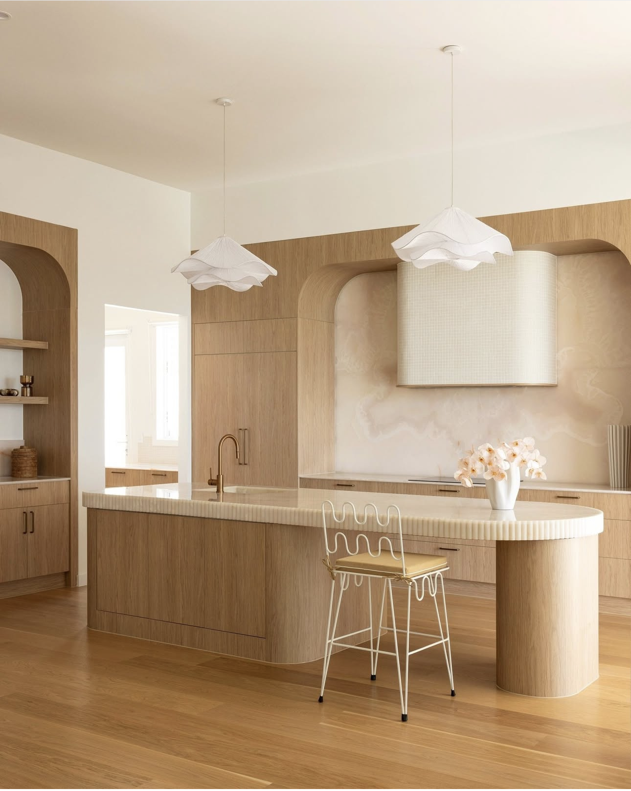 Curved timber kitchen island bench with bar stool seating at the rounded end