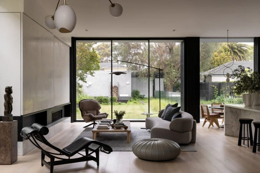 Open plan living room with kitchen and dining visible in one space, and full-height glazing to the garden