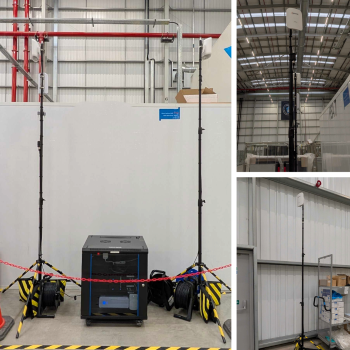 Opious rapid deployment setup in a warehouse — two tripod-mounted wireless access points and compact network stack providing temporary cellular connectivity during a live site migration