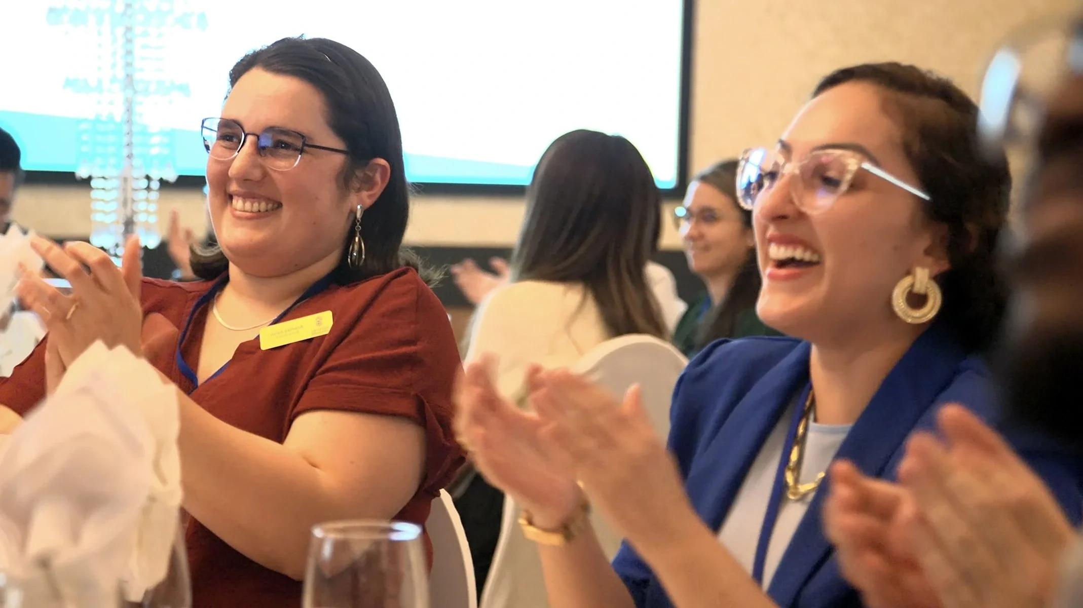two ladies in audience applauding Winnipeg magician Patrick Gregoire